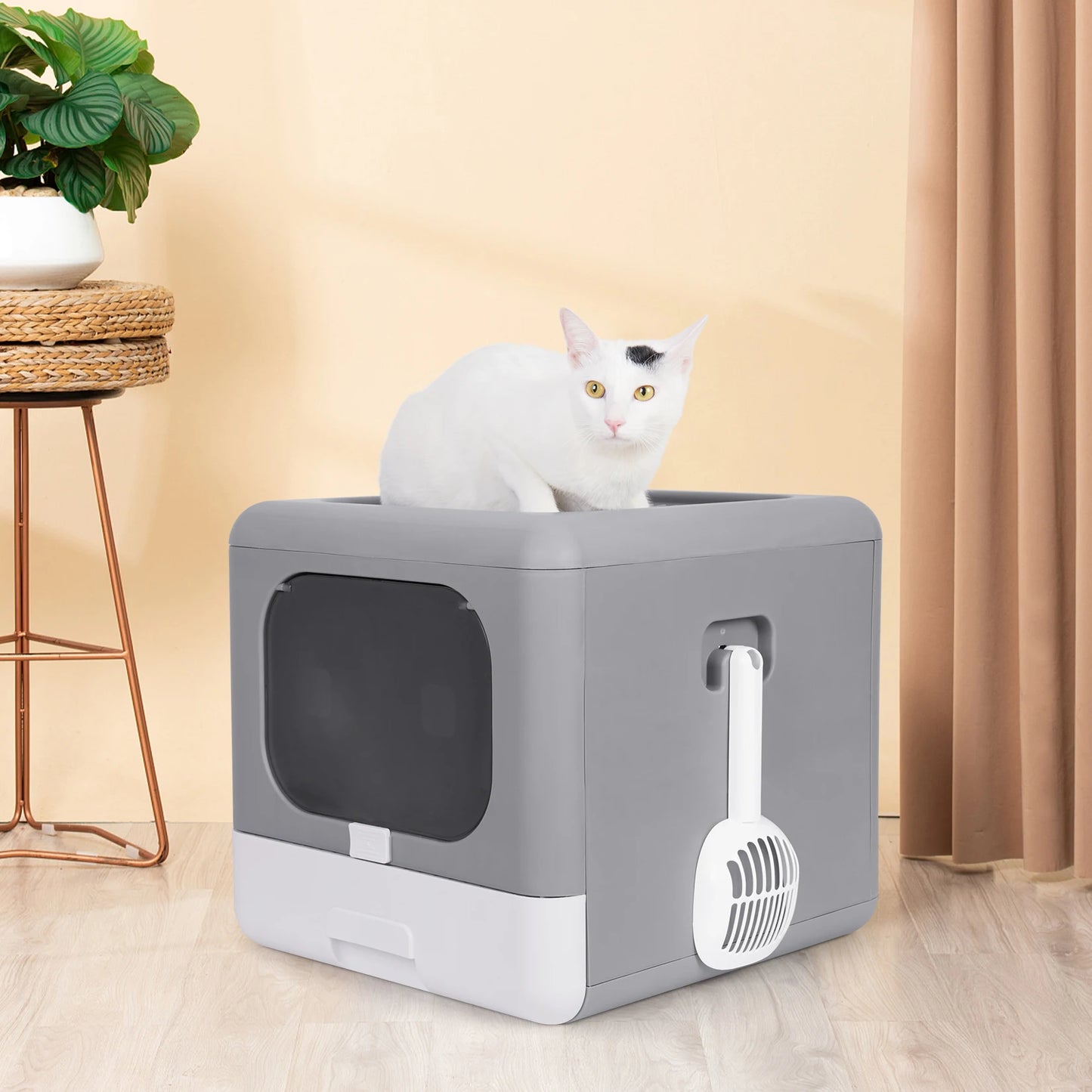 gray enclosed litter box with attachable scooper and cat sitting ontop