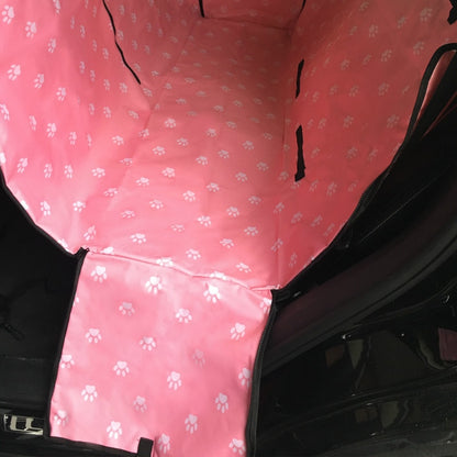 Back seat automotive pet cover in pink with white paw prints.