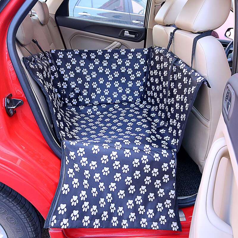 Single seat automotive pet carrier in black with white paw prints, shown partially zipped in back seat.