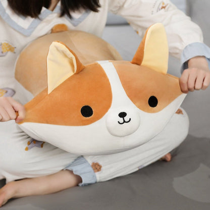 person squeezing the cheeks of plush corgi stuffed animal toy