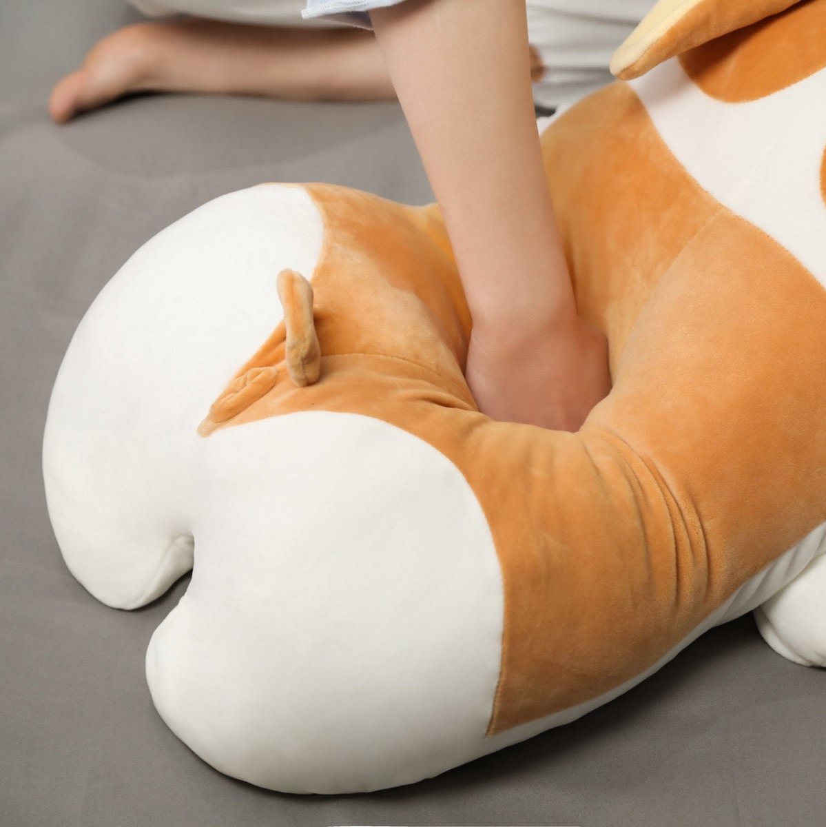 person squishing plush corgi stuffed animal toy