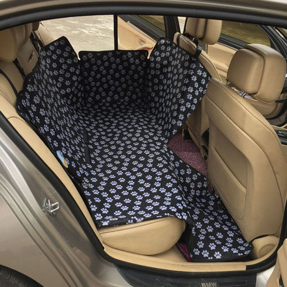 Back seat automotive pet cover in black with white paw prints.