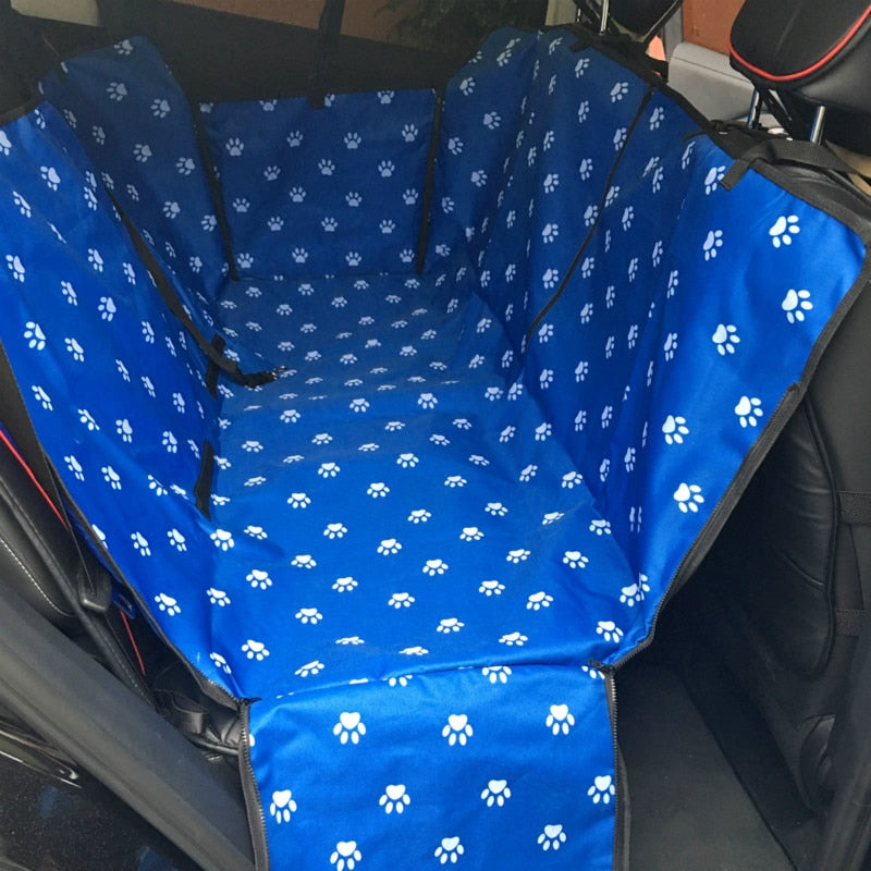 Back seat automotive pet cover in blue with white paw prints.