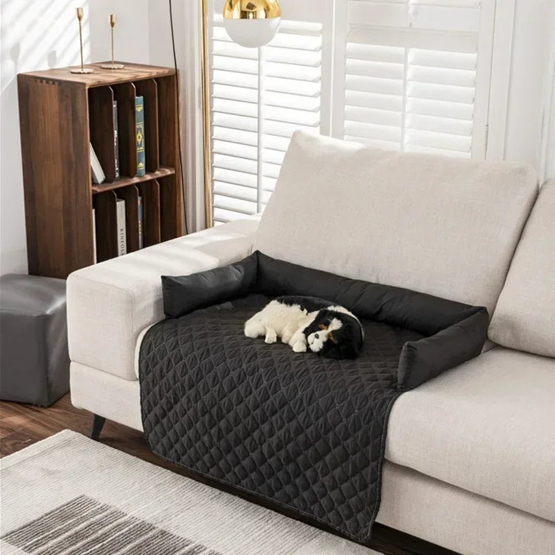 black partial patterned couch cover with bolsters and dog on top