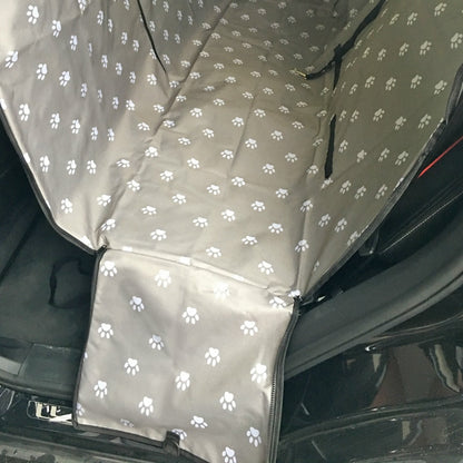 Back seat automotive pet cover in gray with white paw prints.