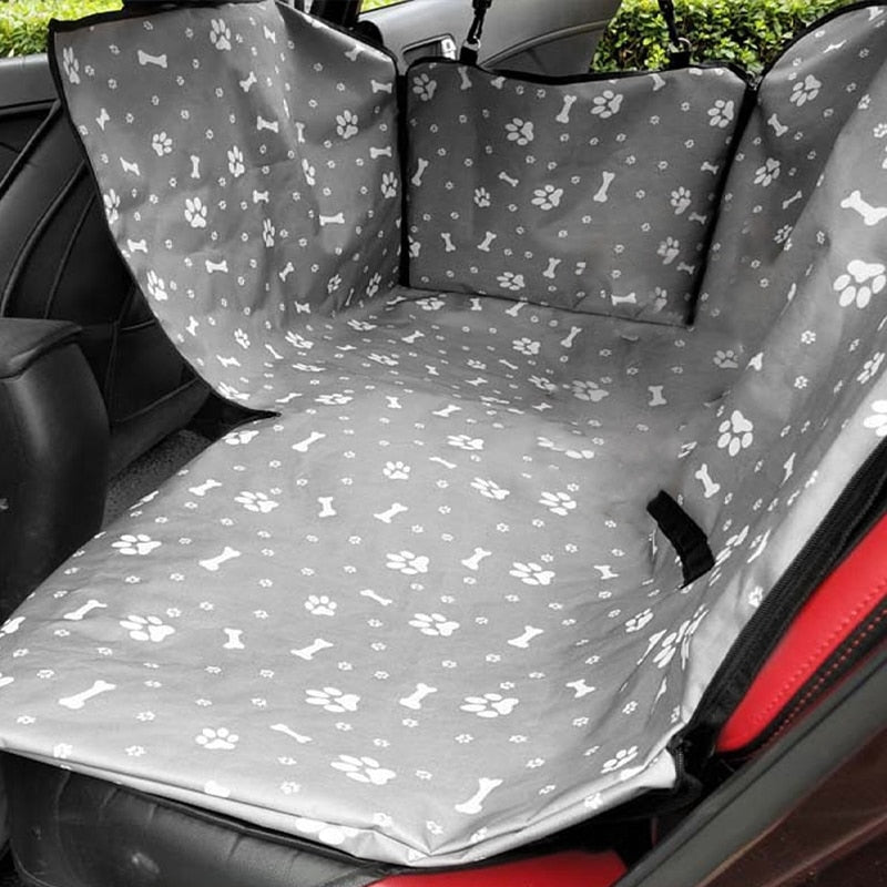 Back seat automotive pet cover in gray with white bone and paw prints.