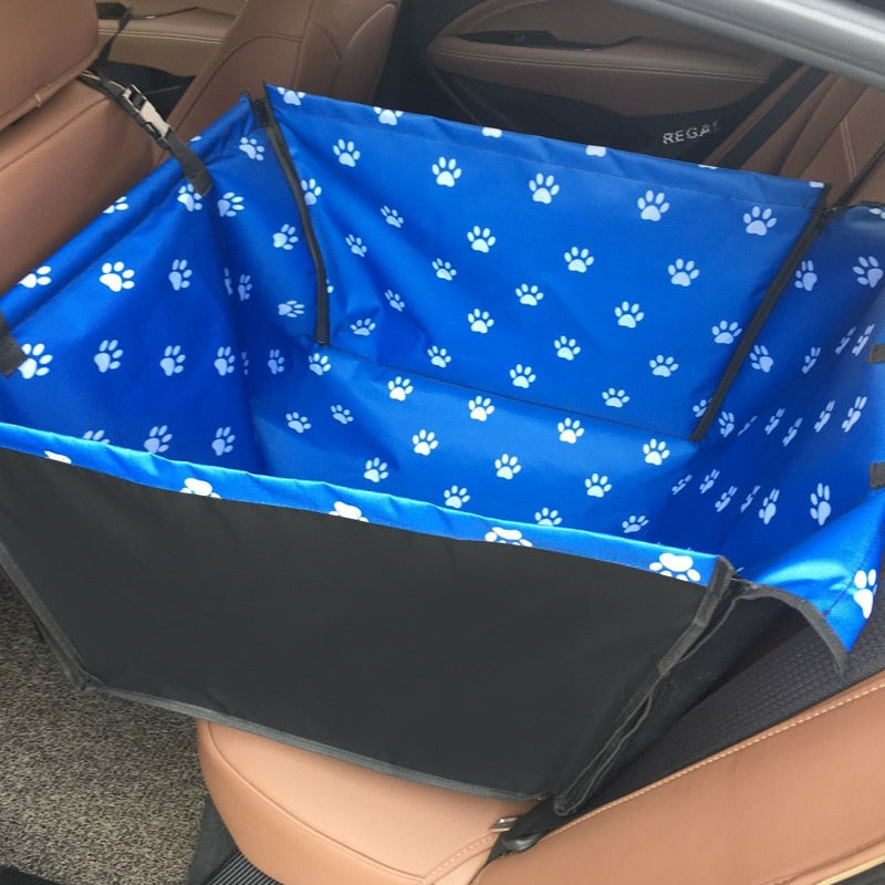 Single seat automotive pet carrier in blue with white paw prints, shown fully zipped