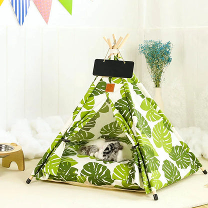 white 5 sided pet tipi tent with green tropical leaves print and cat sleeping inside shown in room.