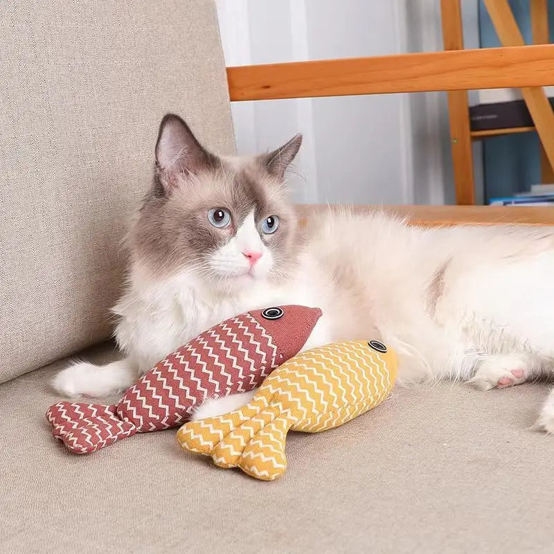 cat shown with one red and one yellow koi fish toy