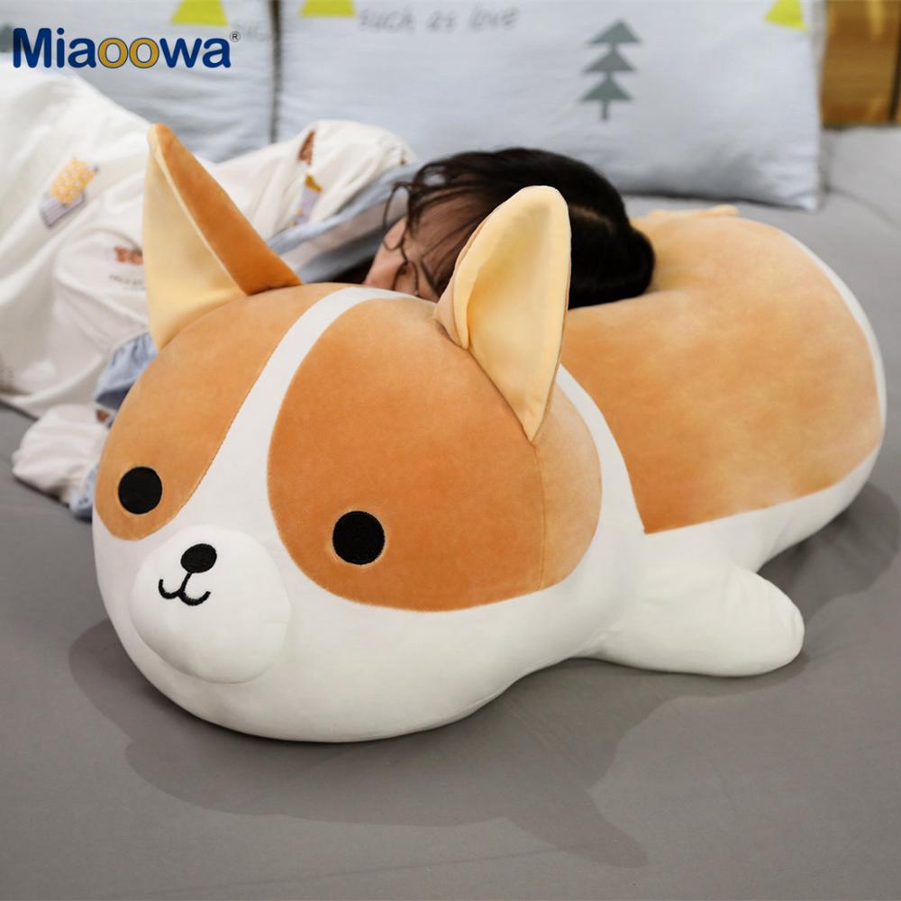 person laying on large plush corgi stuffed animal toy