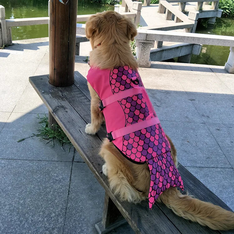 golden retriever dog wearing mermaid style lifejacket and sitting atop a bench