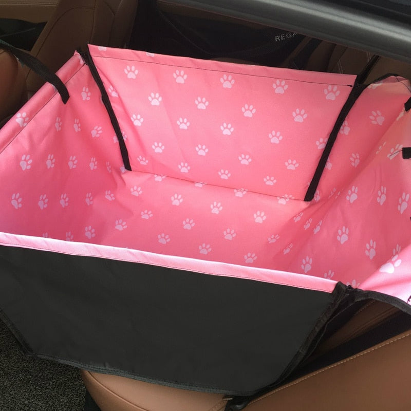 Single seat automotive pet carrier in pink with white paw prints, shown fully zipped.