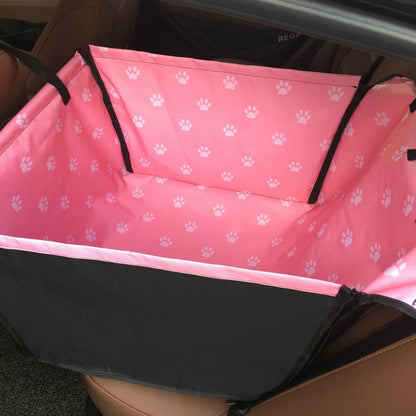 Single seat automotive pet carrier in pink with white paw prints, shown fully zipped.